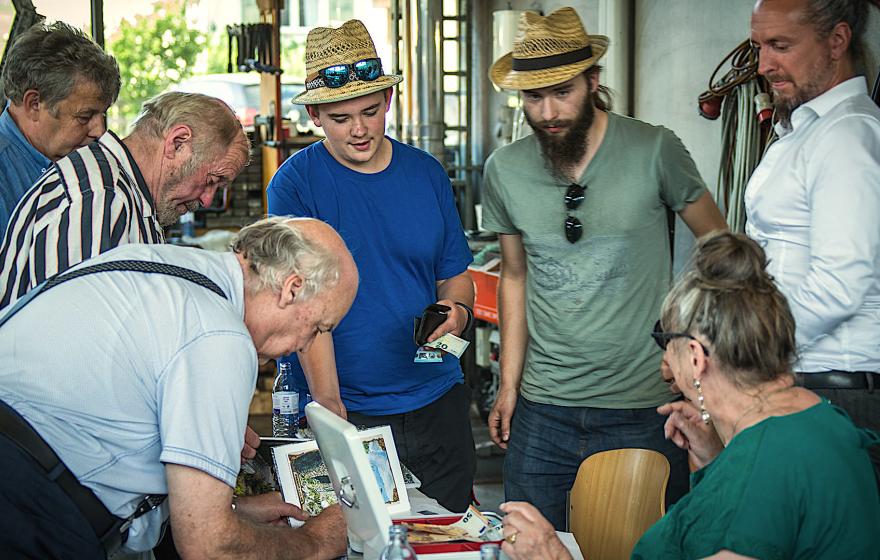 Die Autoren Norbert Fink (li. vorne) und Peter Balmer (am re. Bildrand) beim Signieren der Bücher.